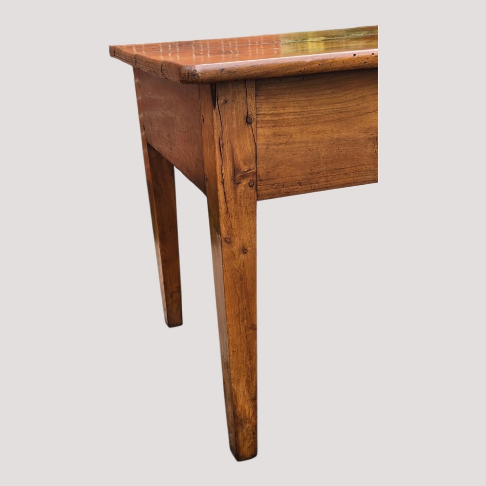 A rectangular French cherry wood refectory dining table featuring a three-plank top, side frieze drawer with metal handle, and square tapered legs. View XII