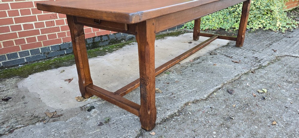 A long solid French oak refectory dining table featuring a plank top and straight legs connected by a low stretcher. View III