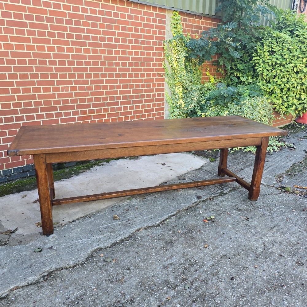 A long solid French oak refectory dining table featuring a plank top and straight legs connected by a low stretcher. View VI