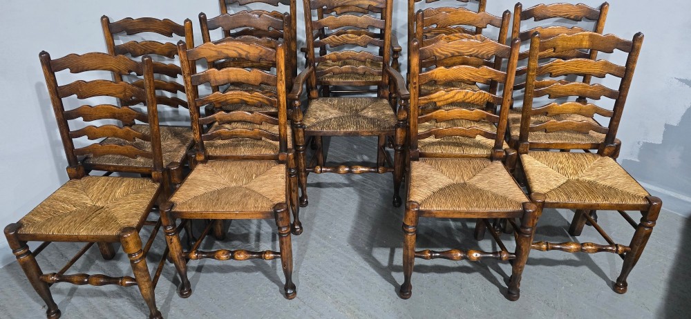 A set of twelve oak dining chairs featuring shaped ladder back slats, natural rush seats, and turned front legs. View VIII