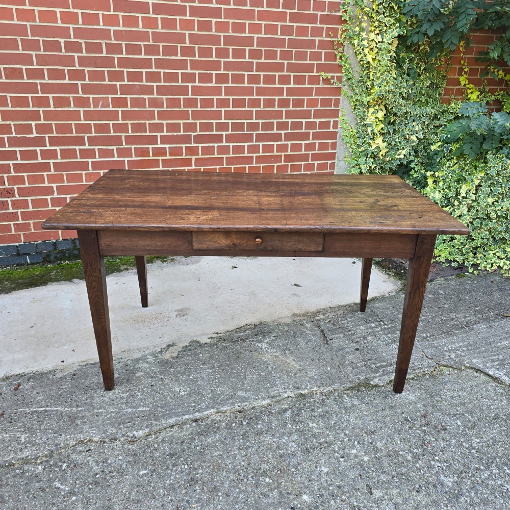 A rectangular rustic oak dining table featuring a frieze drawer with a wooden knob and four square tapered legs. View II