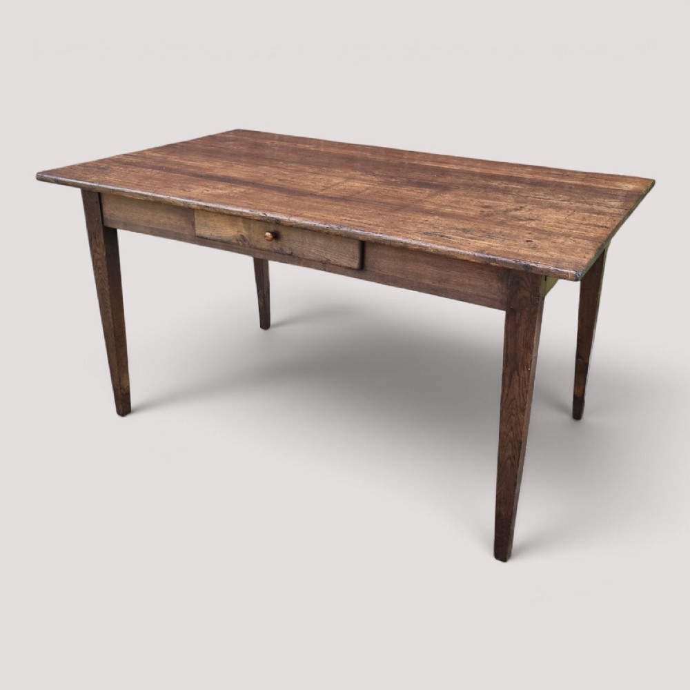 A rectangular rustic oak dining table featuring a frieze drawer with a wooden knob and four square tapered legs. View III