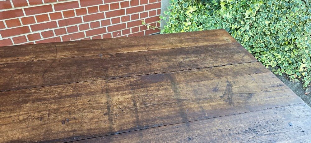 A rectangular rustic oak dining table featuring a frieze drawer with a wooden knob and four square tapered legs. View XI