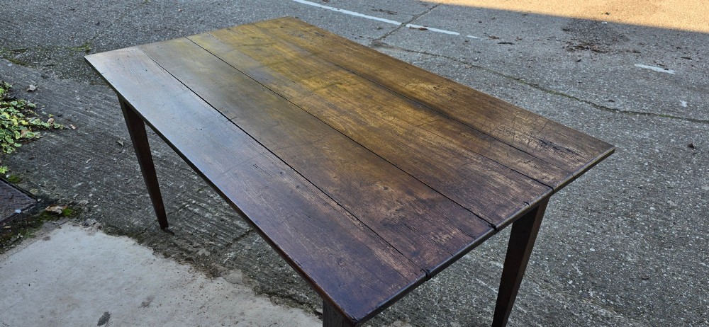 A rectangular rustic oak dining table featuring a frieze drawer with a wooden knob and four square tapered legs. View XIV