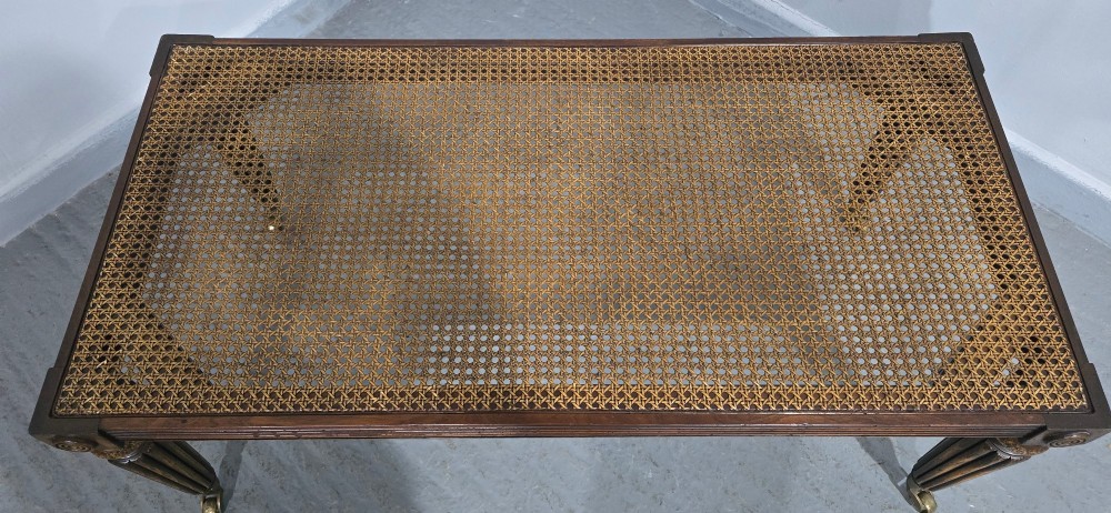 A rectangular Regency bench featuring tan leather upholstery, a reeded dark wood frame, tapered carved legs, and brass castors. View VIII