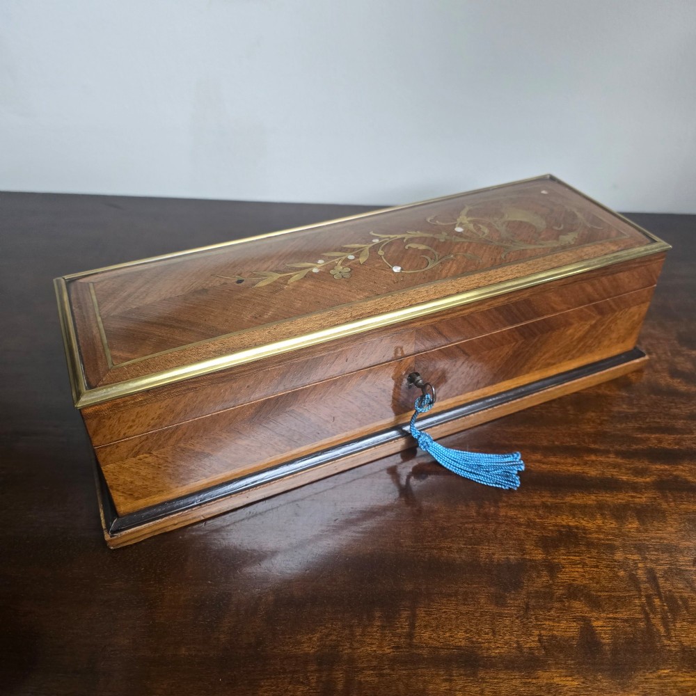 A rectangular antique French wooden glove box with floral marquetry inlay on the lid and a blue tassel attached to the key. View IV