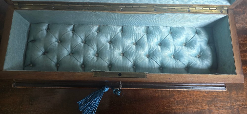 A rectangular antique French wooden glove box with floral marquetry inlay on the lid and a blue tassel attached to the key. View VII