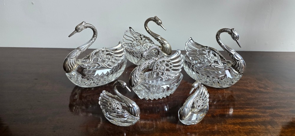 A group of cut glass open salt cellars shaped like swans with silver heads and detailed pierced silver wings. View III