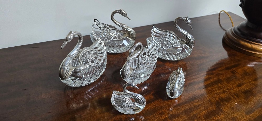 A group of cut glass open salt cellars shaped like swans with silver heads and detailed pierced silver wings. View V