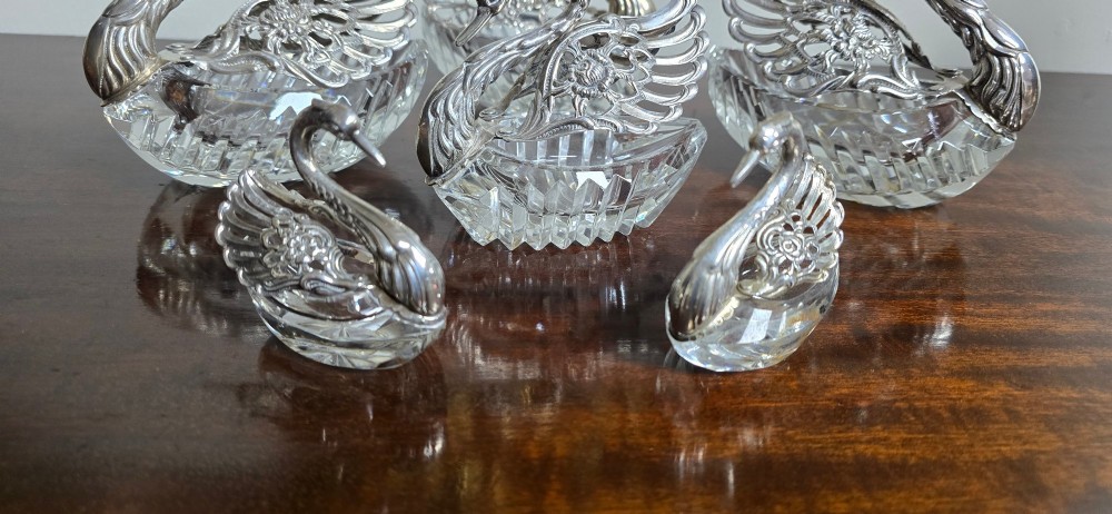 A group of cut glass open salt cellars shaped like swans with silver heads and detailed pierced silver wings. View VI