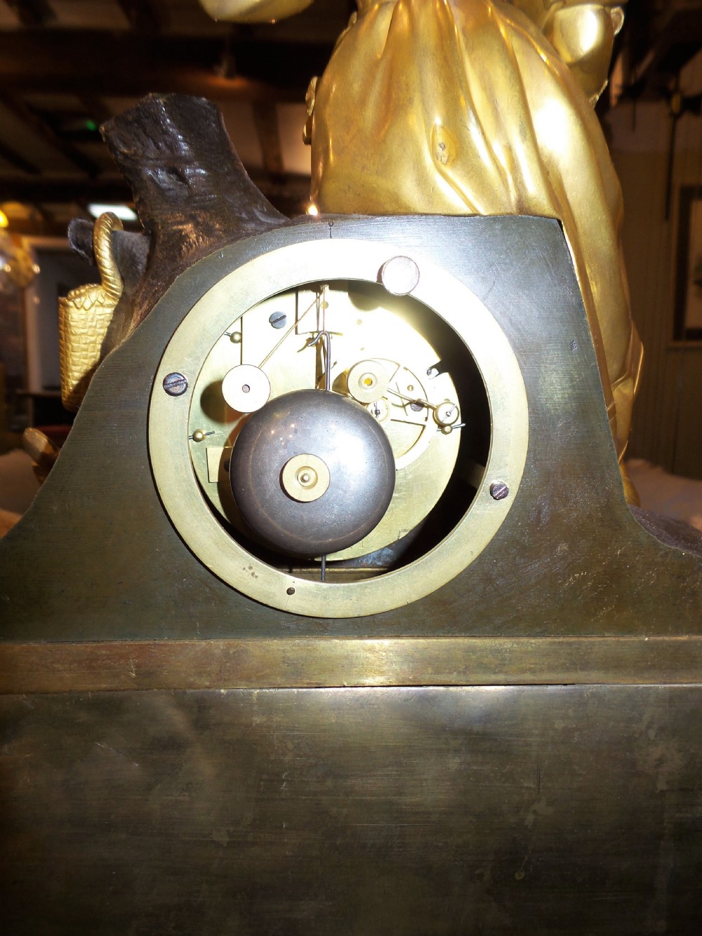 A mid-19th-century French gilt bronze and patinated bronze mantel clock featuring a seated female figure holding a fan atop an ornate sculpted base. View IV