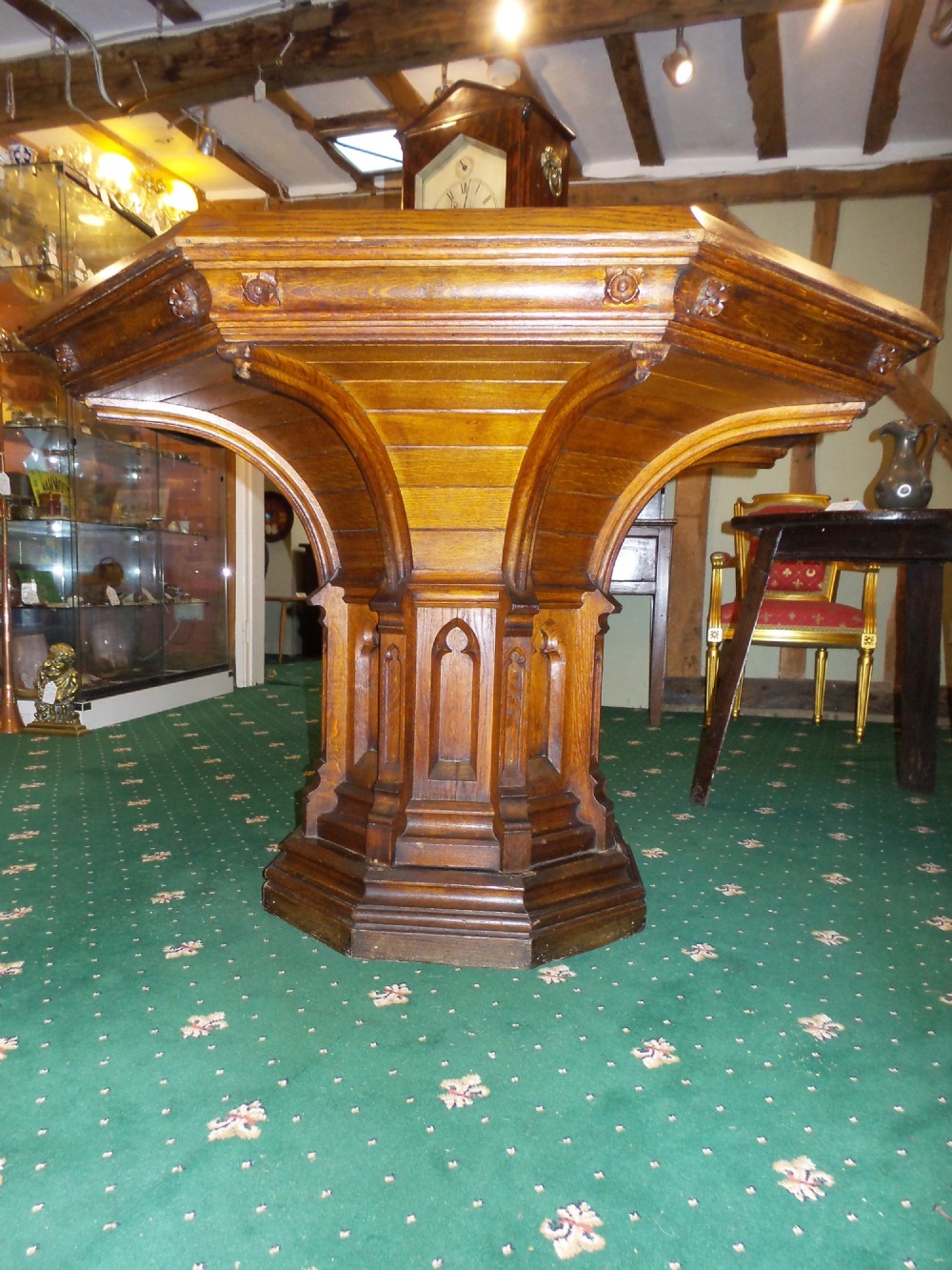 A 19th-century octagonal oak centre table in the Gothic Revival style featuring a carved pedestal base with blind arches and a faceted plinth. View II