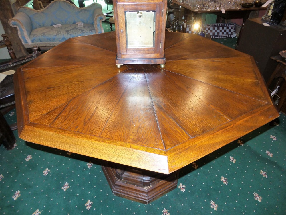 A 19th-century octagonal oak centre table in the Gothic Revival style featuring a carved pedestal base with blind arches and a faceted plinth. View IV