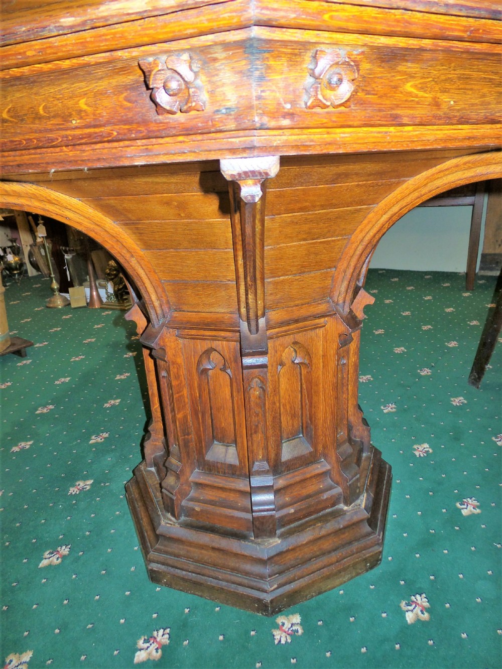 A 19th-century octagonal oak centre table in the Gothic Revival style featuring a carved pedestal base with blind arches and a faceted plinth. View V