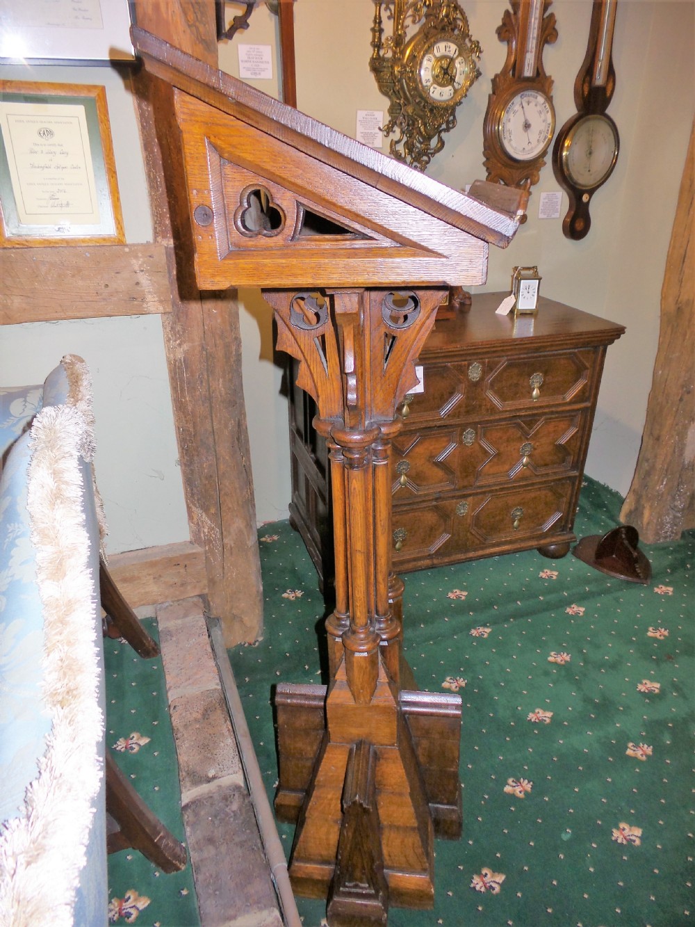 A nineteenth-century carved dark oak Gothic Revival lectern featuring a sloped reading surface, pierced tracery shaft, and stepped base. View III
