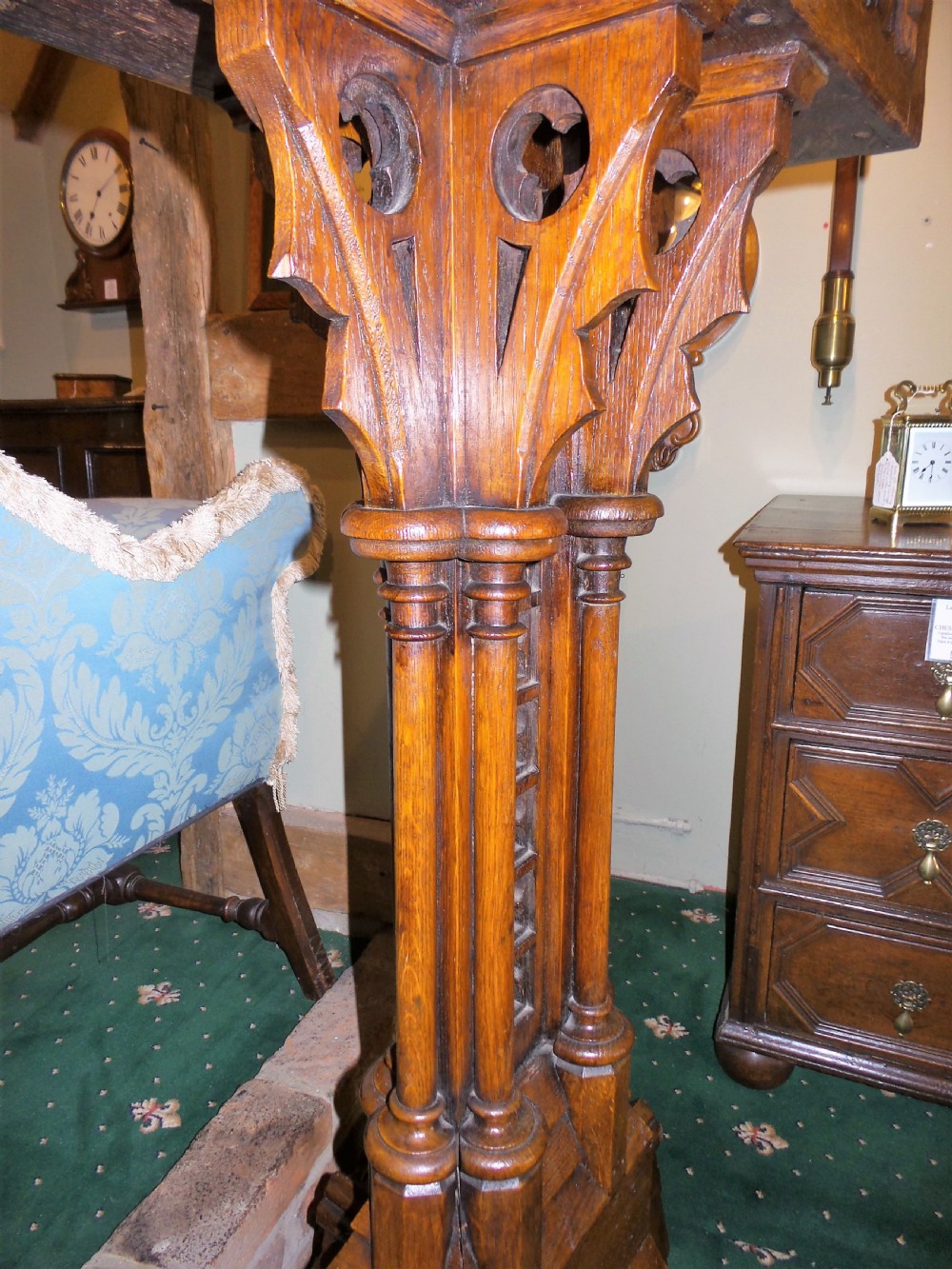 A nineteenth-century carved dark oak Gothic Revival lectern featuring a sloped reading surface, pierced tracery shaft, and stepped base. View VI