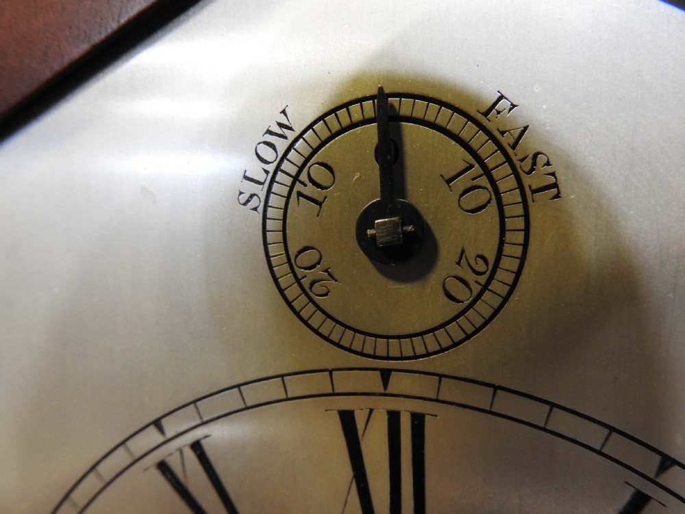 An antique Regency flame mahogany bracket clock featuring a gabled top, a silvered dial signed Vulliamy London, and brass ball feet. View VI