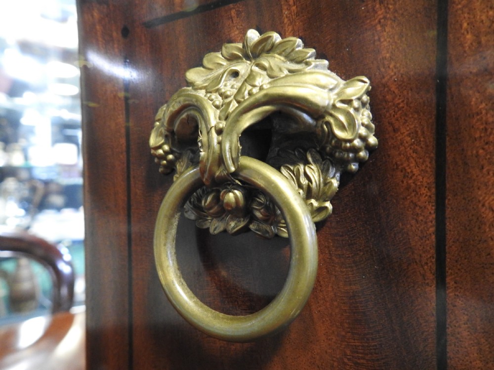 An antique Regency flame mahogany bracket clock featuring a gabled top, a silvered dial signed Vulliamy London, and brass ball feet. View XIV