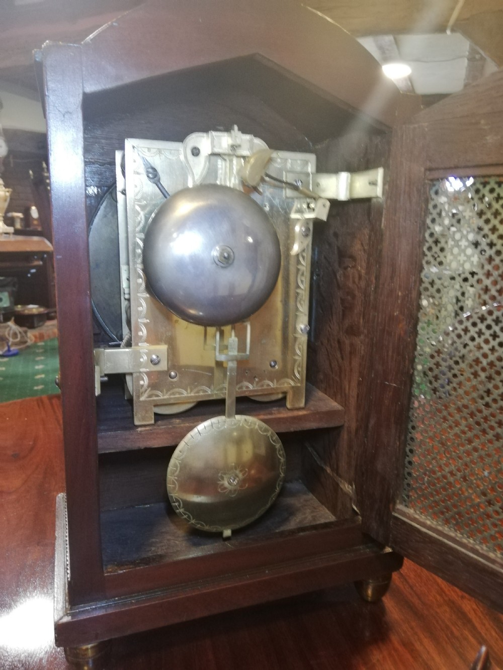 An antique mahogany bracket clock featuring an arched top, inlaid woodwork, a white dial with Roman numerals signed W. Clark London, and brass bun feet. View II