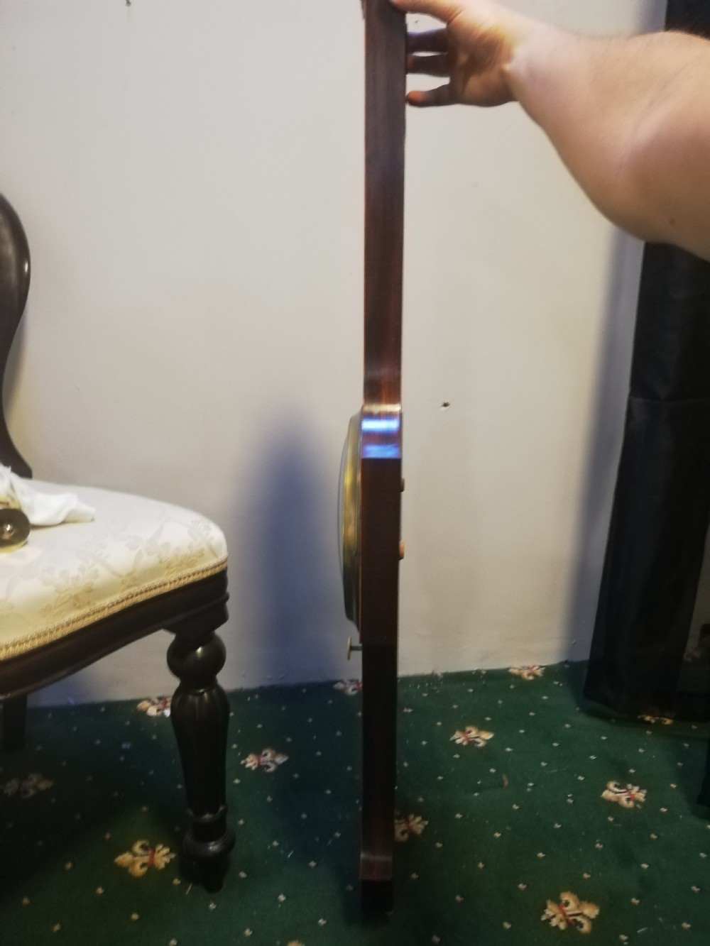 An antique Georgian mahogany wheel barometer featuring a silvered dial with brass bezel, dark wooden casing with inlay, and a pediment top. View XII