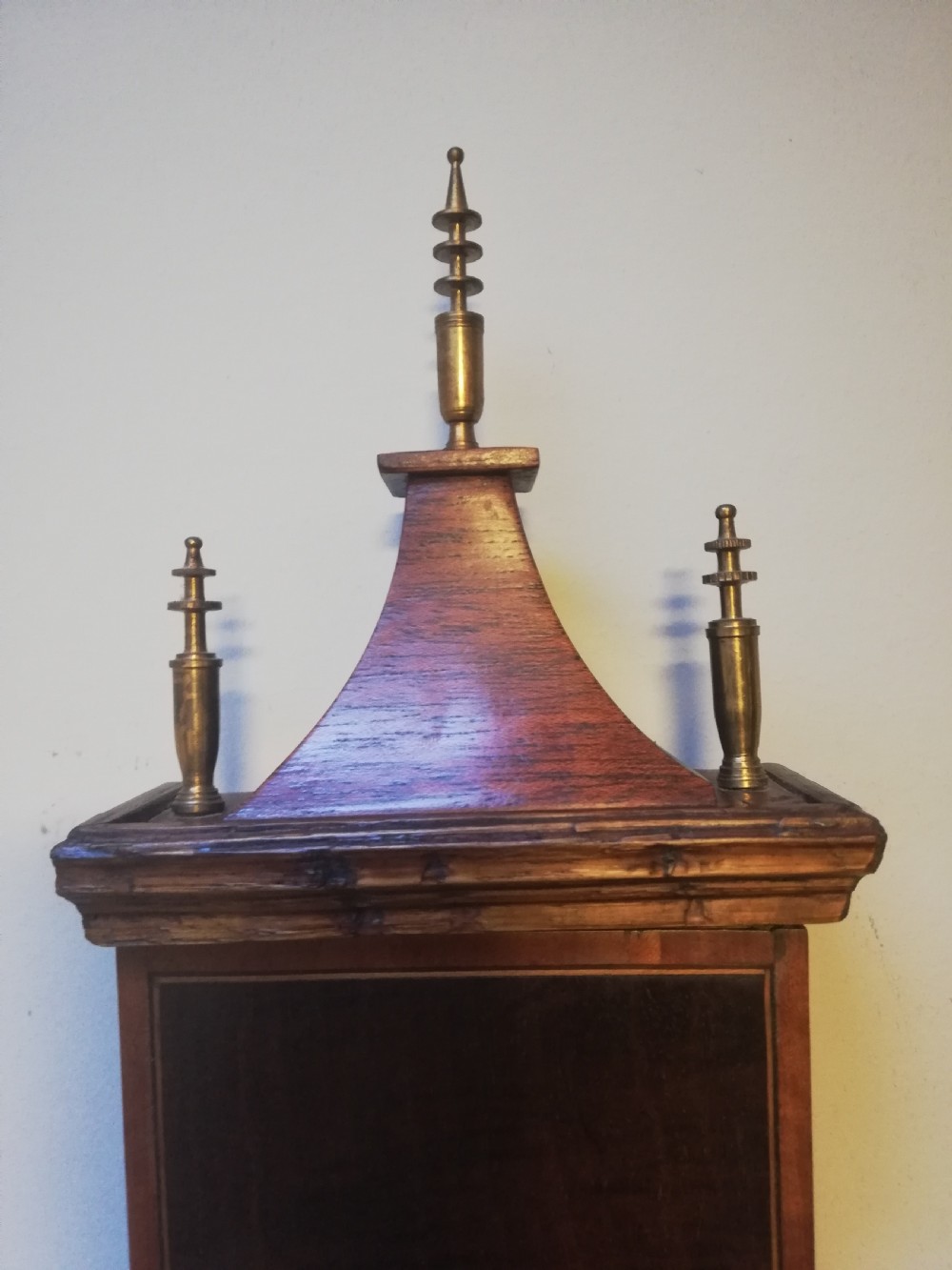 An antique Georgian mahogany wheel barometer featuring a silvered dial with brass bezel, dark wooden casing with inlay, and a pediment top. View XX