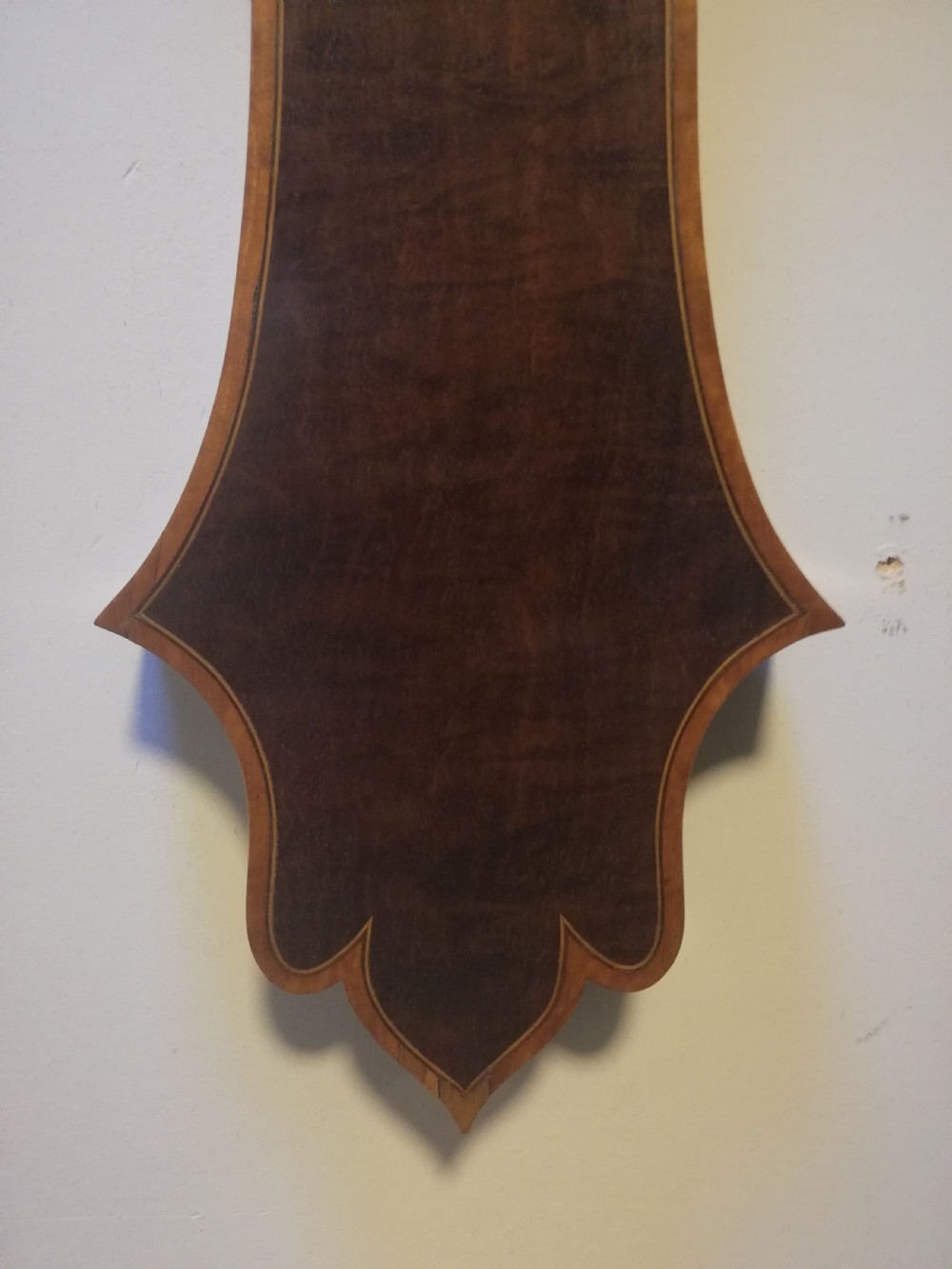 An antique Georgian mahogany wheel barometer featuring a silvered dial with brass bezel, dark wooden casing with inlay, and a pediment top. View XXII