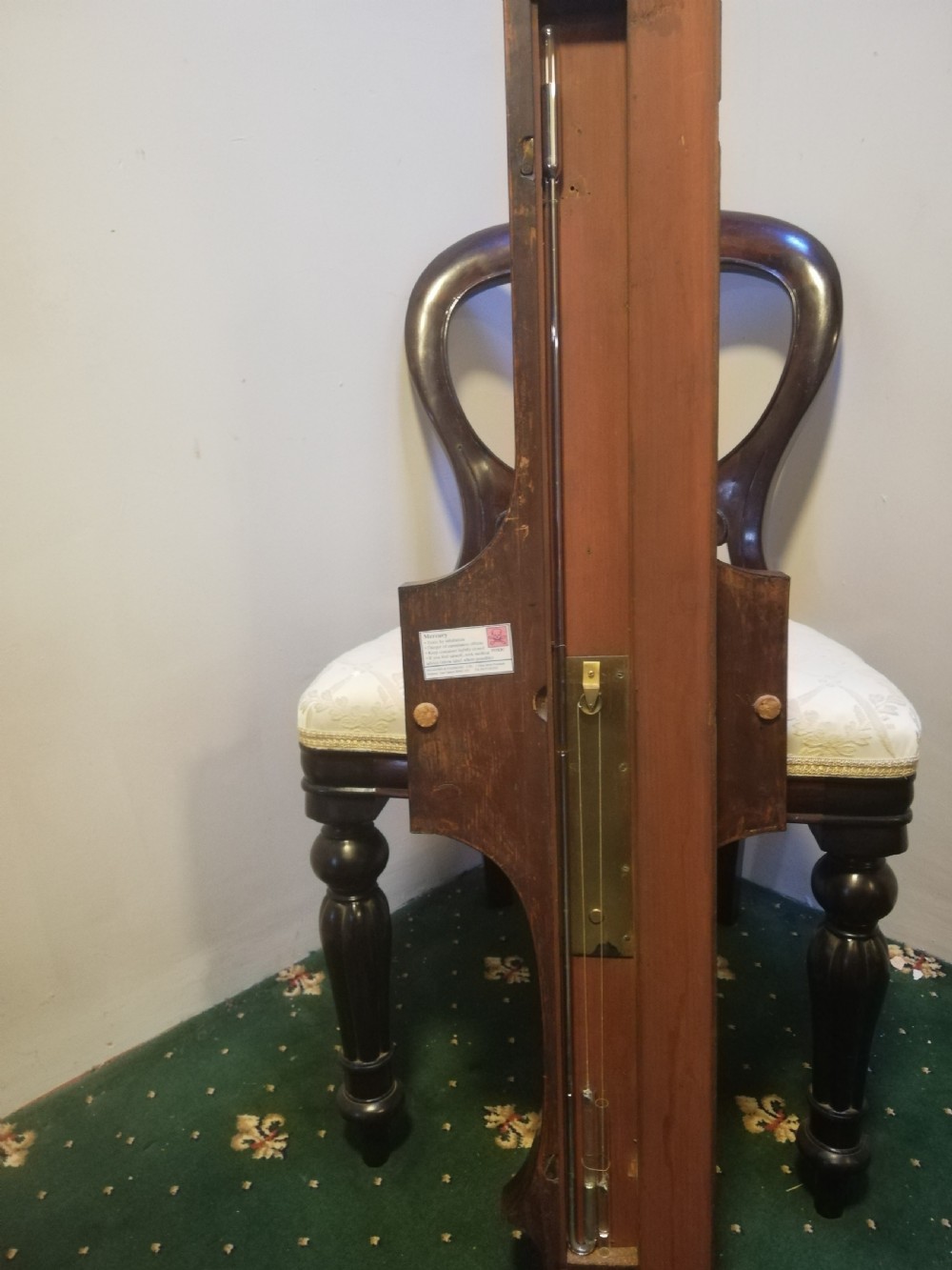An antique Georgian mahogany wheel barometer featuring a silvered dial with brass bezel, dark wooden casing with inlay, and a pediment top. View XXVII