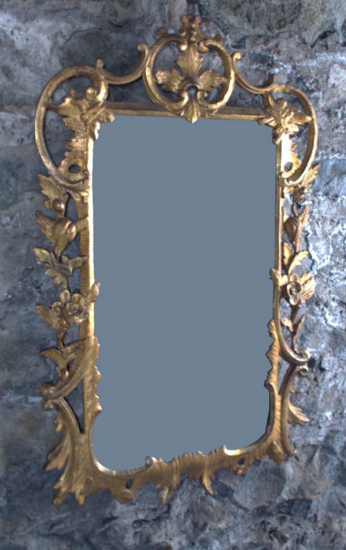 fig 1. A small George III carved giltwood wall mirror featuring pierced scrolling acanthus leaves, floral motifs, and a rectangular central glass pane.