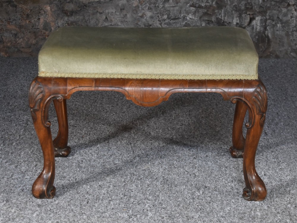 A rectangular George I style walnut stool featuring carved cabriole legs with shell motifs and a sage green velvet seat. View III