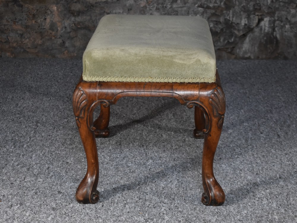 A rectangular George I style walnut stool featuring carved cabriole legs with shell motifs and a sage green velvet seat. View IV