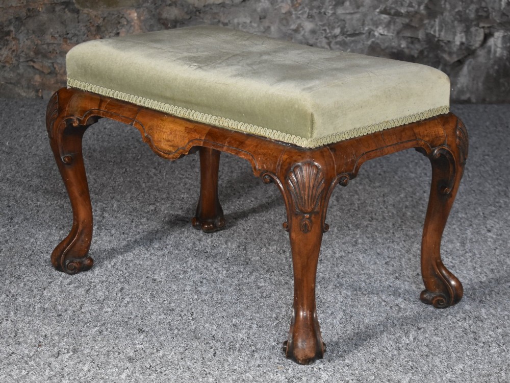 A rectangular George I style walnut stool featuring carved cabriole legs with shell motifs and a sage green velvet seat. View V