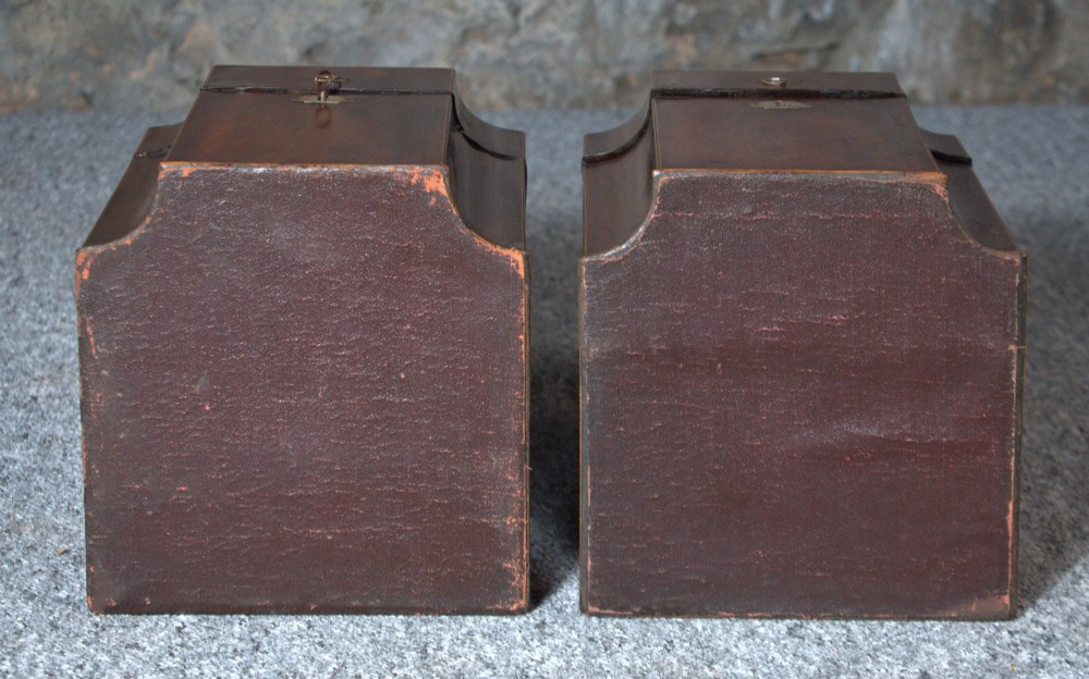 A pair of late eighteenth-century George III mahogany knife boxes featuring sloped lids, serpentine fronts, and brass ring fittings. View V