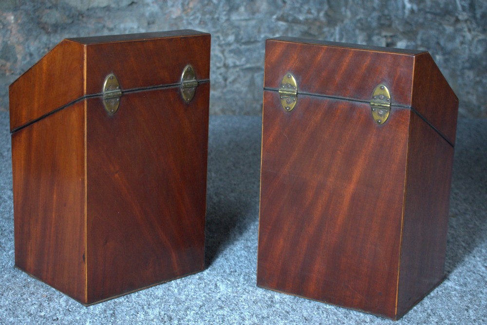 A pair of late eighteenth-century George III mahogany knife boxes featuring sloped lids, serpentine fronts, and brass ring fittings. View VI
