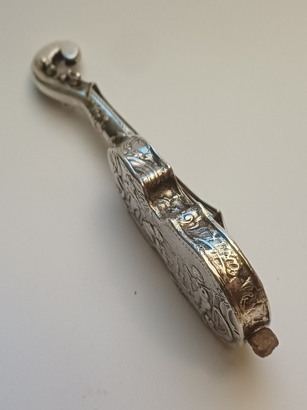 A miniature 19th-century Dutch silver scent bottle crafted in the shape of a violin with engraved scenes and silver wire strings. View III