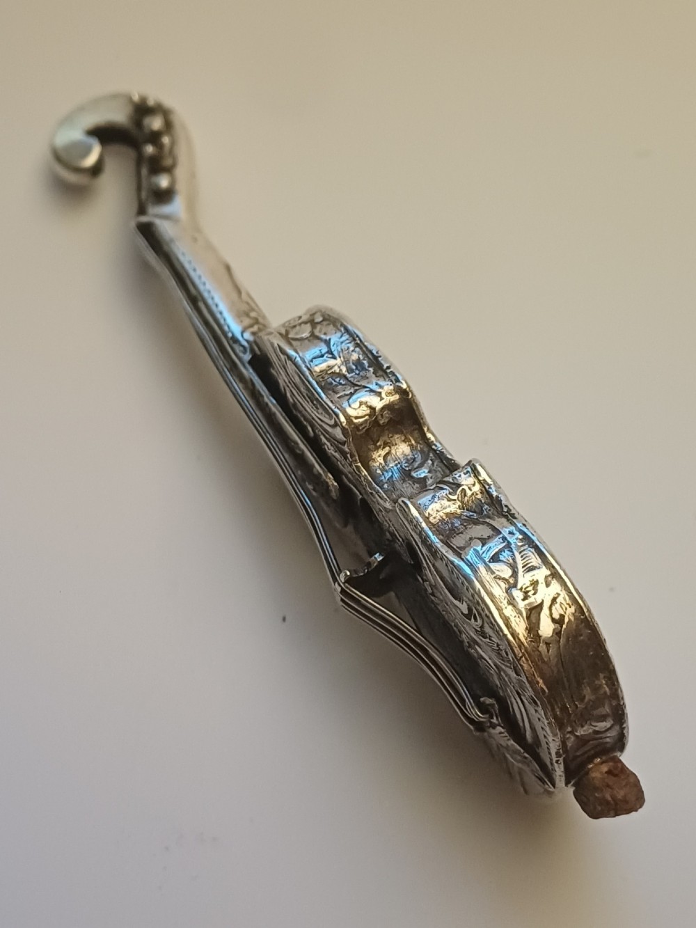 A miniature 19th-century Dutch silver scent bottle crafted in the shape of a violin with engraved scenes and silver wire strings. View IV