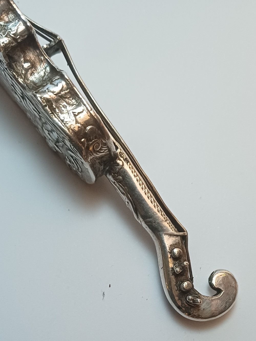 A miniature 19th-century Dutch silver scent bottle crafted in the shape of a violin with engraved scenes and silver wire strings. View X