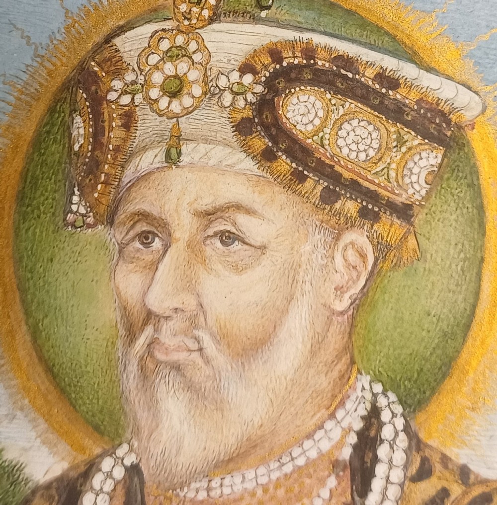 An oval portrait miniature painting of Mughal Emperor Akbar II wearing a jewelled turban, set within an illuminated floral border and a gilded wooden frame. View II