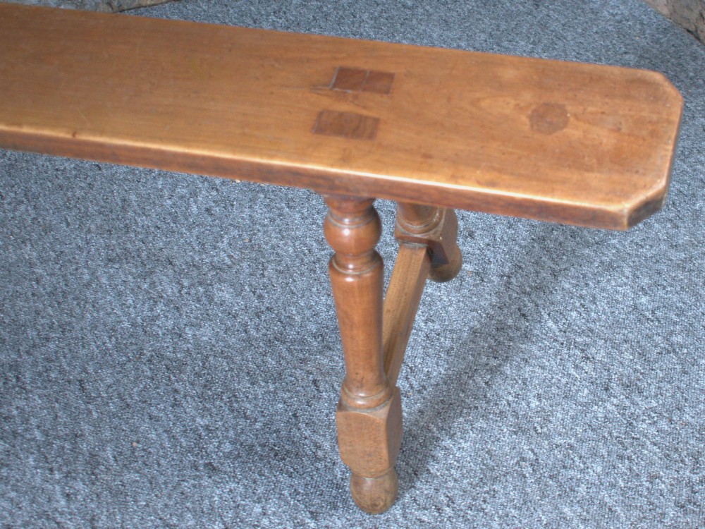 A pair of long 19th-century cherry wood benches with turned trestle legs, stretchers, and smooth timber tops. View IV