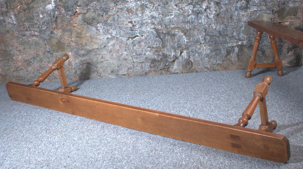 A pair of long 19th-century cherry wood benches with turned trestle legs, stretchers, and smooth timber tops. View V