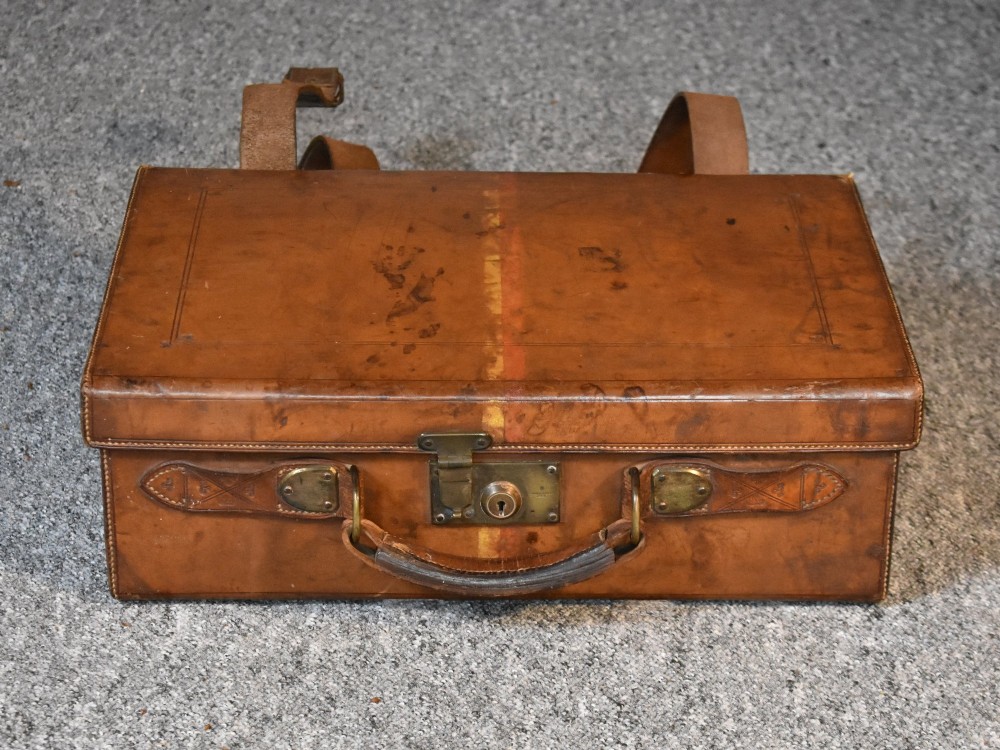 Late 19th-century tan leather cartridge case featuring an oak core, double leather straps, central brass lock, and stitched carrying handle. View IV