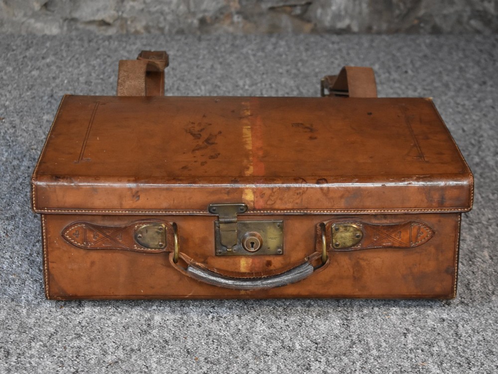 Late 19th-century tan leather cartridge case featuring an oak core, double leather straps, central brass lock, and stitched carrying handle. View II