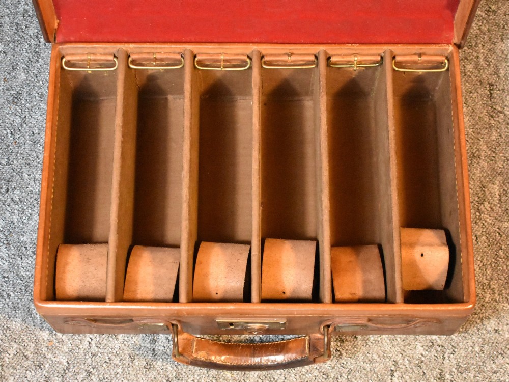 Late 19th-century tan leather cartridge case featuring an oak core, double leather straps, central brass lock, and stitched carrying handle. View III