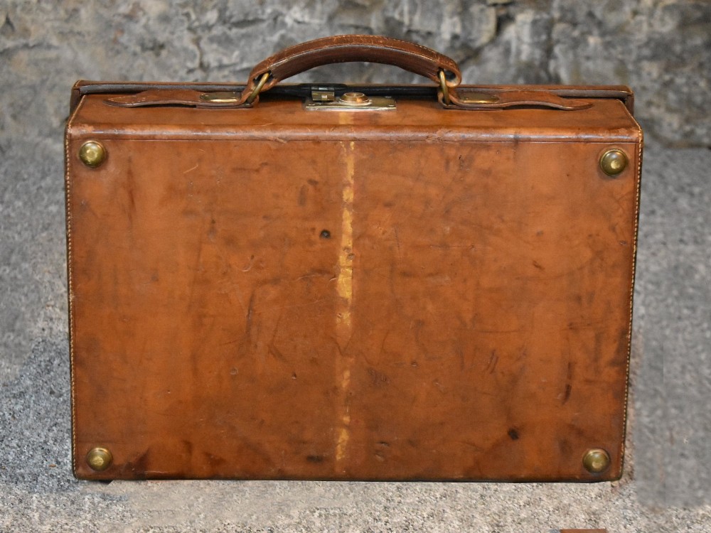 Late 19th-century tan leather cartridge case featuring an oak core, double leather straps, central brass lock, and stitched carrying handle. View IX