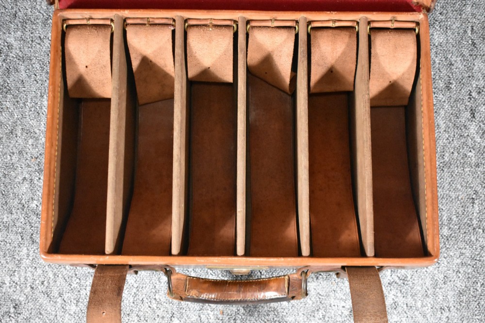 Late 19th-century tan leather cartridge case featuring an oak core, double leather straps, central brass lock, and stitched carrying handle. View XI