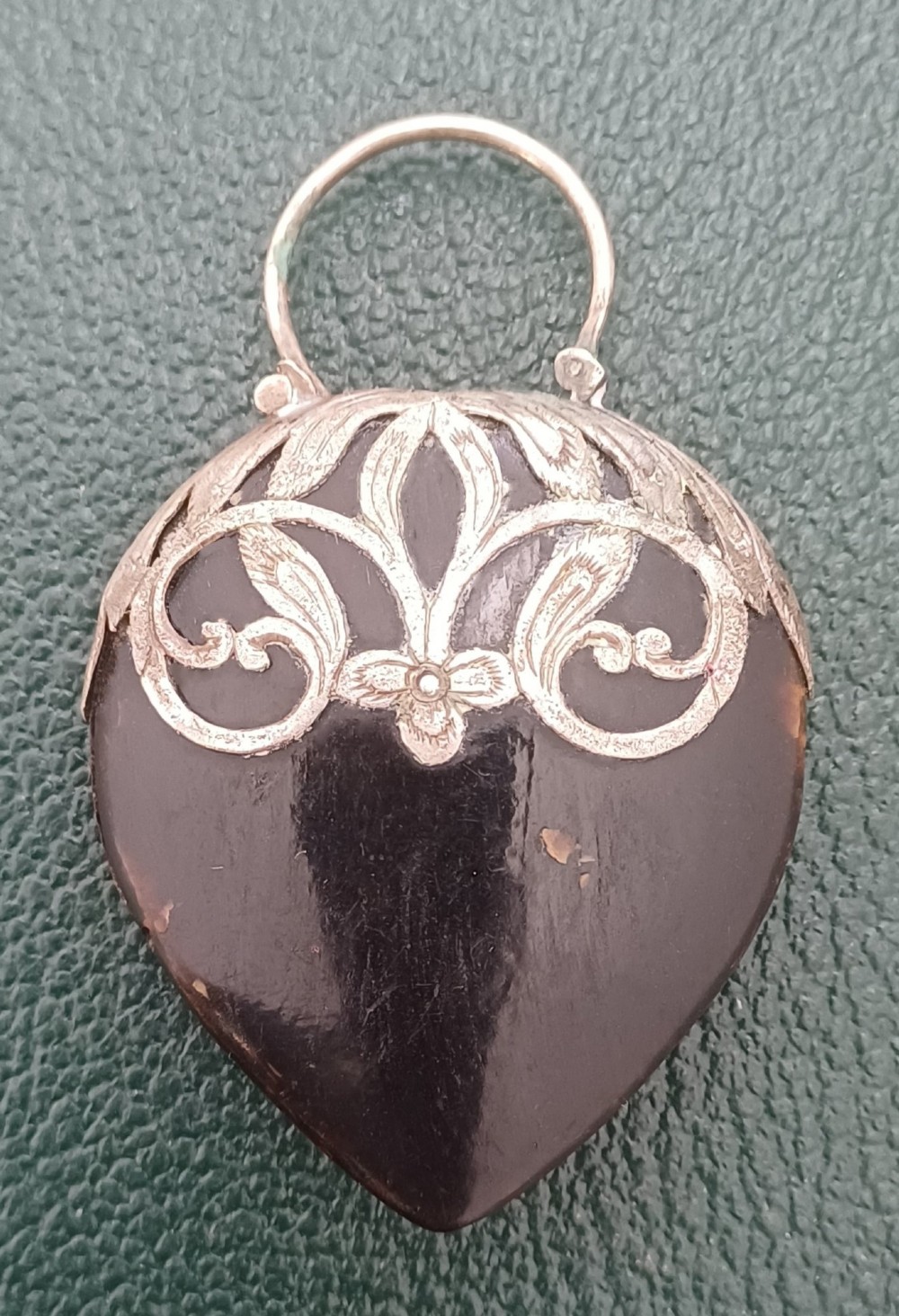A Victorian heart-shaped tortoiseshell pendant featuring ornate silver scrollwork mounting and a keyhole motif with a top hanging loop. View III