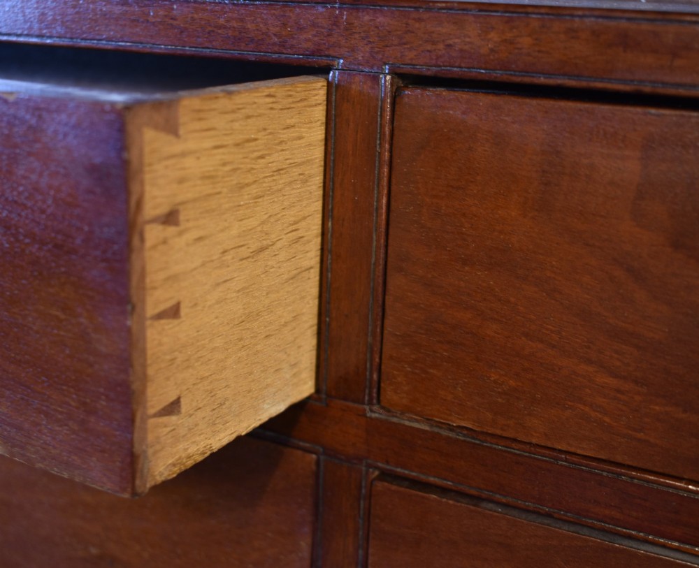 A George III mahogany wall-mounted shelf unit featuring three open display tiers set above four drawers with brass swan-neck handles. View III
