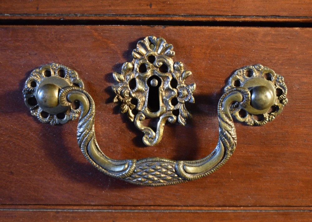A George III mahogany wall-mounted shelf unit featuring three open display tiers set above four drawers with brass swan-neck handles. View IV