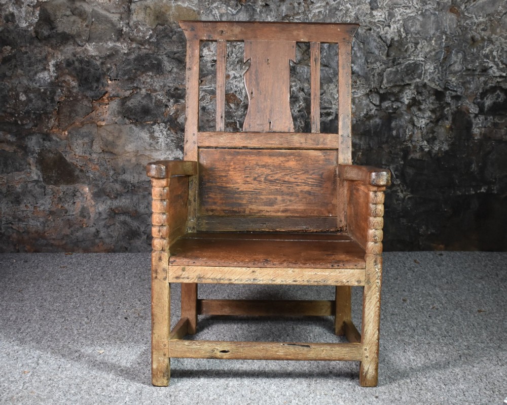 An 18th-century Scottish crofter armchair featuring turned front arm posts, panelled sides, and a slatted back in a warm wood finish. View II