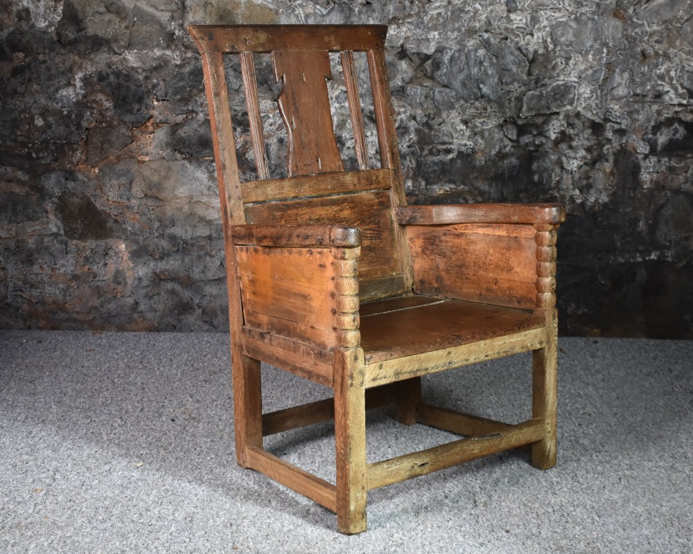 An 18th-century Scottish crofter armchair featuring turned front arm posts, panelled sides, and a slatted back in a warm wood finish. View III