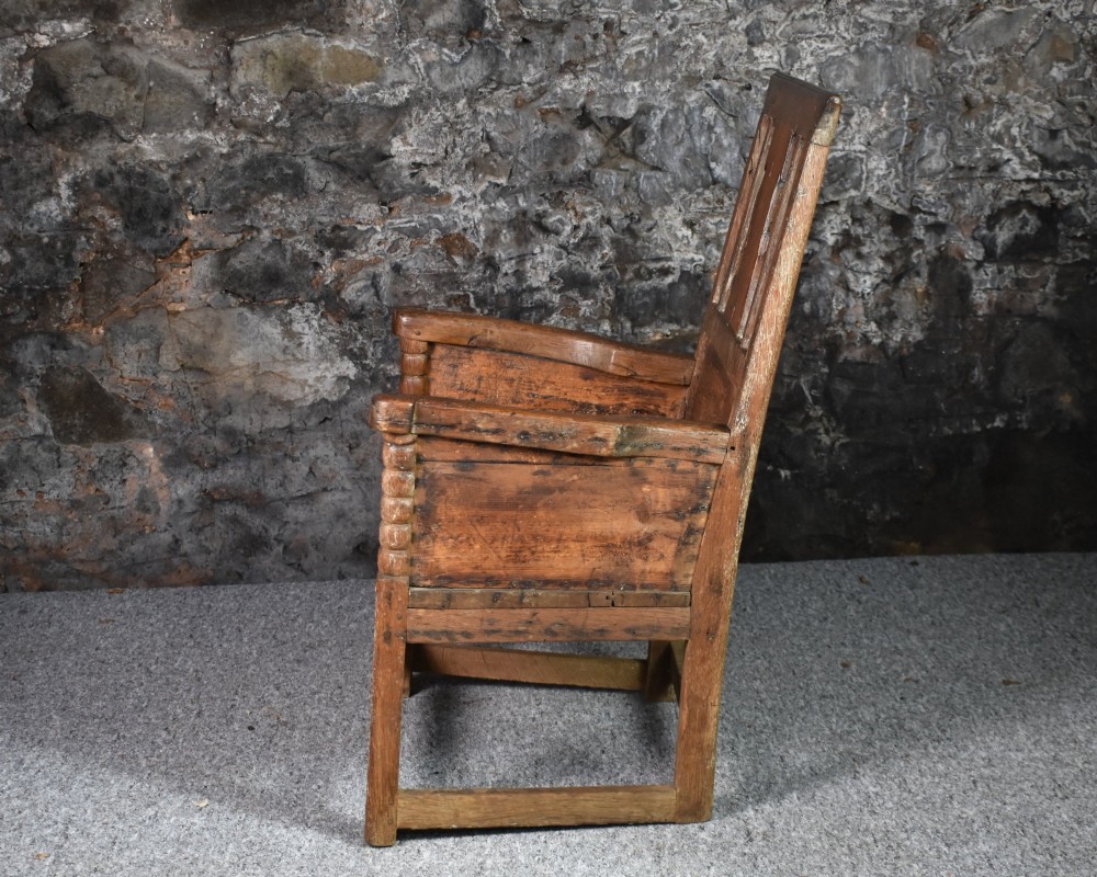 An 18th-century Scottish crofter armchair featuring turned front arm posts, panelled sides, and a slatted back in a warm wood finish. View IV